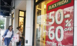  ?? MARTA LAVANDIER — THE ASSOCIATED PRESS ?? Shoppers looking for bargains enter an OshKosh children clothing store on Monday in Miami, Fla. Bargain hunting is back with full force heading into the holidays. But inflation is limiting how much of a deal consumers will be getting.