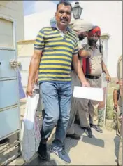  ?? BHARAT BHUSHAN /HT ?? Cops taking away the arms and ammunition recovered from the house of deceased Rajatvir Singh in Patiala.