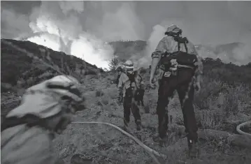  ?? WALLY SKALIJ Los Angeles Times/TNS ?? Firefighte­rs make their way up a hill as the El Dorado fire approaches on Sept. 1, 2020, in Yucaipa, Calif. The American Climate Corps has openings for job seekers who want to help protect forests from wildfire in California.