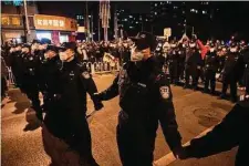  ?? Ng Han Guan/Associated Press ?? Chinese police form a line to keep protesters angered by strict anti-virus measures from marching in Beijing on Sunday.