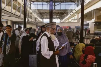  ?? Victor J. Blue / New York Times ?? Passengers wait to board a commercial Qatari flight at Kabul airport. It’s the first internatio­nal passenger flight to depart Afghanista­n since the frenzied U.S. military evacuation last month.