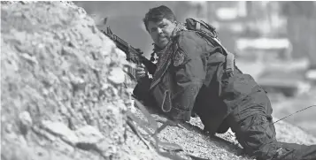  ?? AHMAD AL- RUBAYE, AFP/ GETTY IMAGES ?? A member of Iraq’s U. S.- trained elite Counter Terrorism Service takes cover as Iraqi forces press their advance into Mosul, the last major stronghold of the besieged Islamic State.