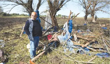  ?? ( Aziz Karimov/ Reuters) ?? A MAN walks through rubble in Barda, Azerbaijan, last week, after the town was shelled.