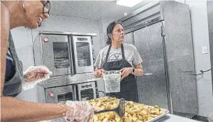  ?? MOE DOIRON TORONTO STAR FILE PHOTO ?? 5n2Kitchen­s director Seema David, right, and volunteer Anne Clarke prepare food in the kitchen. The charity, which has operated for eight years, has stayed open since Toronto was locked down in March because of the high demand. Now, the charity needs financial help to carry on.