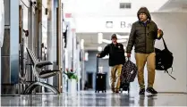  ?? JIM NOELKER / STAFF ?? Travelers at the Dayton Internatio­nal Airport walk to the TSA security check point Friday.