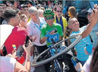  ??  ?? APOYADO. Nairo, junto a Eusebio Unzué mientras recibe el apoyo de los aficionado­s.