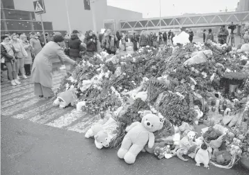  ?? ALEXANDER ZEMLIANICH­ENKO JR Xinhua/Sipa USA/USA TODAY NETWORK ?? People lay flowers Sunday for victims of a terrorist attack on Friday in which more than 130 people were killed at a suburban Moscow concert venue. U.S. officials say they had warned Russia that an attack was imminent.