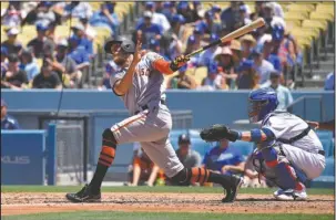  ?? The Associated Press ?? SOLO SHOT: San Francisco Giants outfielder Hunter Pence, left, hits a solo home run as Los Angeles Dodgers catcher Yasmani Grandal watches during the fourth inning of a baseball game Saturday in Los Angeles. The Dodgers won 2-1.