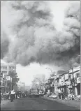  ?? US NATIONAL ARCHIVES/AFP ?? Black smoke covers areas of Saigon and fire trucks rushing to the streets of fires set during attacks by the Viet Cong during the festive Tet holiday period in Saigon in 1968.