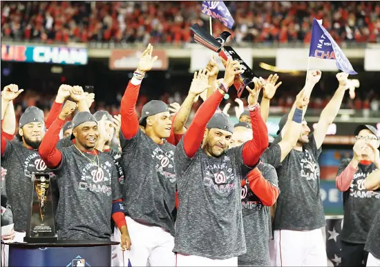  ?? (AP) ?? Washington Nationals manager Dave Martinez raises the NLCS trophy after Game 4 of the National League Championsh­ip Series against the St Louis Cardinals on Oct 15 in Washington. The
Nationals won 7-4 to win the series 4-0.