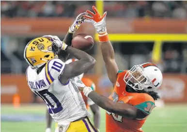  ?? RON JENKINS/AP ?? LSU wide receiver Stephen Sullivan and Miami defensive back Romeo Finley battle for a pass that was later ruled incomplete.