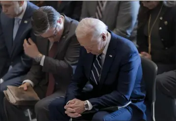  ?? PHOTOS BY SCOTT APPLEWHITE — THE ASSOCIATED PRESS ?? President Joe Biden, with House Minority Leader Hakeem Jeffries, D-N.Y., left, and House Speaker Mike Johnson of Louisiana, pray and listen during the National Prayer Breakfast on Feb. 1at the Capitol in Washington. Johnson has spoken in the past of his belief America was founded as a Christian nation. Biden, while citing his own Catholic beliefs, has spoken of values shared by people of “any other faith, or no faith at all.”