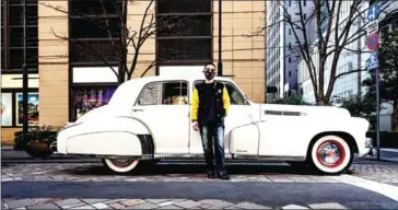  ?? AFP ?? Trucking company executive Yuji Nakayama poses for a photo in front of a 1941 Cadillac during a gathering of auto enthusiast­s in Tokyo.