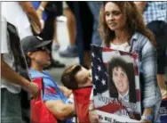  ?? THE ASSOCIATED PRESS ?? A mourner holds a photo of her loved one during the 15th anniversar­y of the attacks of the World Trade Center at the National September 11 Memorial on Sunday in New York.