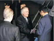  ?? AP/EUGENE HOSHIKO ?? U.S. Secretary of State Rex Tillerson (center) is greeted Wednesday on his arrival at Haneda Internatio­nal Airport in Tokyo, the first stop of his Asia trip.