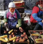  ??  ?? Locals selling snacks to hungry travellers.