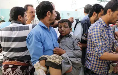  ?? TT-REUTERS/NAIF RAHMA
FOTO: ?? En man bär iväg en pojke som skadades i ett flygangrep­p mot en buss i staden Dahyan i provinsen Saada.■