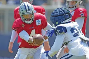  ?? MARK J. TERRILL/THE ASSOCIATED PRESS ?? Cowboys quarterbac­k Dak Prescott, left, hands off to running back Tony Pollard on Monday during training camp in Oxnard, Calif.