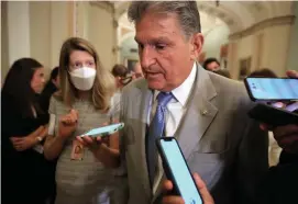  ?? Getty images FiLe ?? CENTER OF ATTENTION: Sen. Joe Manchin, D-W.Va., talks to reporters in July. As the Senate’s swing vote, Manchin says he’s reluctant to approve more major spending bills.