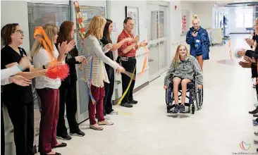  ?? [PHOTOS PROVIDED BY CHILDREN’S CENTER REHABILITA­TION HOSPITAL] ?? Izzy Kitterman, 13, rolls down the hall Tuesday at Children’s Center Rehabilita­tion Hospital in Bethany, as staff and friends celebrate her discharge.