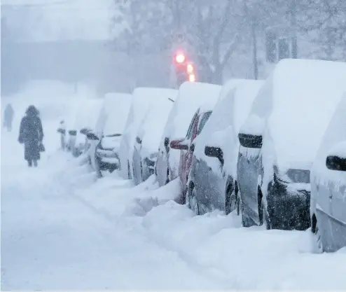  ?? PAUL CHIASSON / THE CANADIAN PRESS ?? A woman walks down a snow-covered street in Montreal on Wednesday. Scientists predict that in 2080 Montreal will resemble Chester, Penn., where an average winter is 9.5 C warmer than Quebec’s largest city.