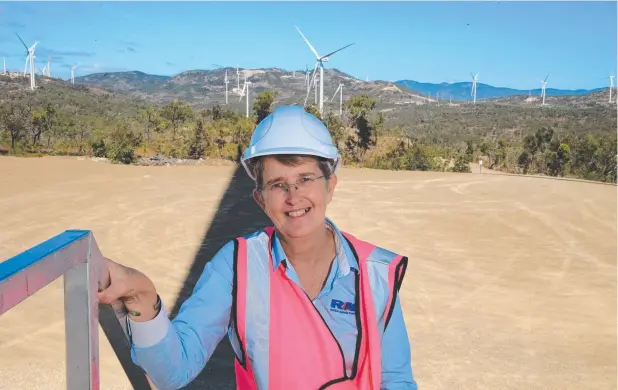  ?? Pictures: JUSTIN BRIERTY ?? GETTING CLOSE: Ratch Australia community engagement facilitato­r Kim Forde among the large wind turbines at the Mt Emerald Wind Farm.
