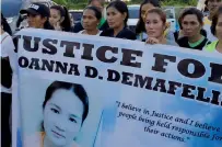  ?? AFP ?? Residents display placards as they wait for the arrival of the body of Joanna Demafelis in her hometown in Iloilo province. —