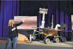  ?? Marcio Jose Sanchez / Associated Press ?? Mars 2020 project system engineer Jennifer Trosper, left, points to a replica of the Mars Exploratio­n Rover Opportunit­y during a briefing at NASA’s Jet Propulsion Laboratory.