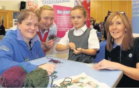  ??  ?? Guiding hand Niamh Loughlin ( 7) tries crafting with Girl Guide volunteers from Ayrshire South; Carol Thomson, Linda Bamford and Angela Lindsay 111017Fore­hill_ 9