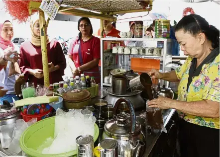  ??  ?? Pro at work: Ang busy making her famous coffee as customers queue up at her Star Coffee stall in Noordin Street, just a block away from Komtar in George Town.