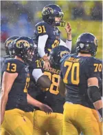  ?? DAVID DERMER, AP ?? Teammates carry kicker April Goss off the field Saturday after she converted an extra-point attempt in Kent State’s win vs. Delaware State.