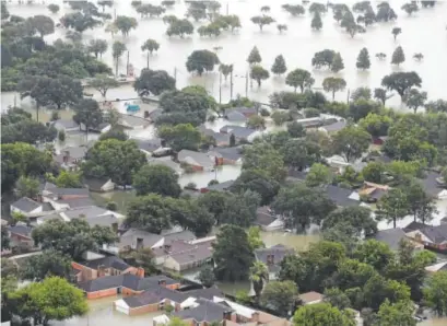  ?? David J. Phillip, Associated Press ?? Homes are flooded in Houston as floodwater­s rise on Tuesday. It is on the tired backs of the poor that the heaviest burdens of Hurricane Harvey will fall, and they will bear that weight for the longest time.