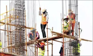  ?? HENG CHIVOAN ?? Constructi­on workers prepare supports for a new overpass in the capital’s Meanchey district.