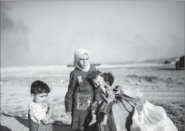  ?? Photog raphs by Bulent Kilic AFP/Getty Images ?? SYRIAN CHILDREN wait after entering Turkey at the Akcakale crossing. Some of the people who f led Tal Abyad, Syria, told of being trapped amid the battle between Islamic State militants and Kurds and their allies.