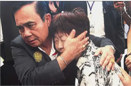  ?? — AP ?? Tragedy and grief: Thailand Prime Minister Prayuth Chan-o-cha consoling a relative of a victim in the boat accident on the island of Phuket.