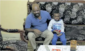  ?? AMR NABIL/THE ASSOCIATED PRESS ?? Sudanese activist Tayeb Ibrahim, who had worked to expose abuses in Sudan and hopes to see family living in Iowa, watches TV with his son Mohammed, in Cairo, Egypt. Dozens of Sudanese activists living in Egypt as refugees and were close to approval for...