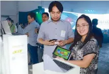  ??  ?? Acer Philippine­s sales and marketing director Agnes Espino holds an Acer Iconia W4 tablet, demonstrat­ing how the new features of Windows 8.1 work.