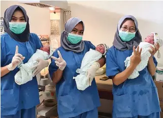  ?? KRIDA HERBAYU/JAWA POS RADAR GENTENG ?? TRIPLET: Tiga perawat menggendon­g tiga bayi kembar yang lahir di sebuah rumah sakit di Kecamatan Gambiran.