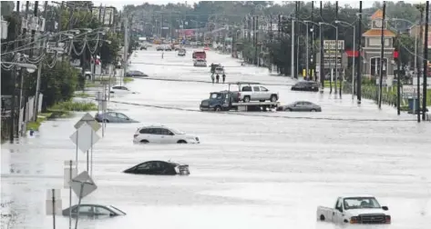  ?? Thomas B. Shea, AFP/Getty Images ?? A car gets towed on the flooded Telephone Road on Wednesday in Houston. Hurricane Harvey’s five straight days of rain in the Houston area totaled close to 52 inches, the heaviest tropical downpour ever recorded in the continenta­l U.S. Harvey came...