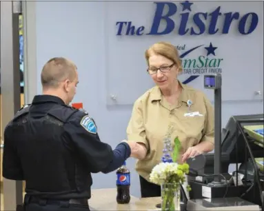  ?? ERIC BONZAR — THE MORNING JOURNAL ?? Cashier Mary Smigel checks out a customer at the newly renovated CommStar Bistro, at Mercy Health, in Lorain, Nov. 14.