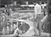  ?? AP/The Philadelph­ia Inquirer/MARGO REED ?? Madisyn Gravely plays in the fountain Thursday at Philadelph­ia’s Dillworth Park as her father, Mike, tries to coax her out.