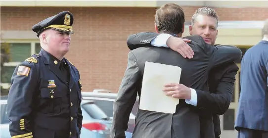  ?? STAFF PHOTOS BY CHRIS CHRISTO ?? SAD DAY: Tewksbury police Chief Timothy Sheehan, above at left, looks on as Jonathan Merz and Ken Ball comfort one another after yesterday’s service for Rhonda LeRocque, above at right, at Tewksbury Memorial High School. Top, other attendees leave the...