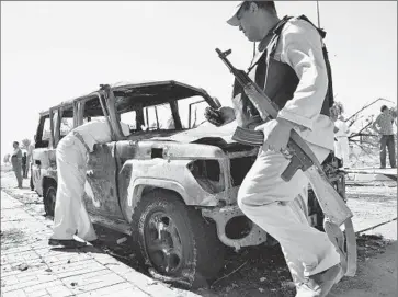  ?? Mostafa Darwish ?? EGYPTIAN SOLDIERS inspect a vehicle at the site of a bombing in El Tor, a town in the Sinai Peninsula. Officials initially said the blast was caused by a car bomb, but later blamed it on a suicide attacker.