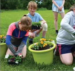  ??  ?? Senior pupils Michelle, Colm, Emma and Louisa planting plants as part of their ‘caring for the enviornmen­t’ learning.