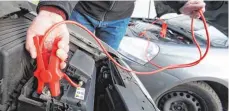  ?? FOTO: DPA ?? Das rote Kabel wird an die Pluspole beider Batterien geklemmt.