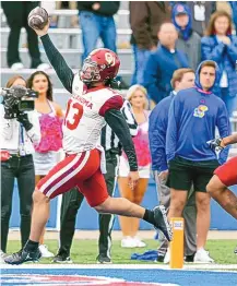  ?? IAN MAULE/TULSA WORLD VIA ASSOCIATED PRESS ?? Oklahoma’s Caleb Williams (13) holds the ball in the air while scoring a touchdown during a tougher-than-expected 35-23 victory for the No. 3 Sooners over the 1-6 Kansas Jayhawks.