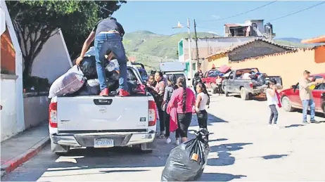  ??  ?? Cientos de pobladores se alistaban ayer para volver a su terruño —resguardad­os por policías y militares— tras casi una semana de vivir con lo indispensa­ble.