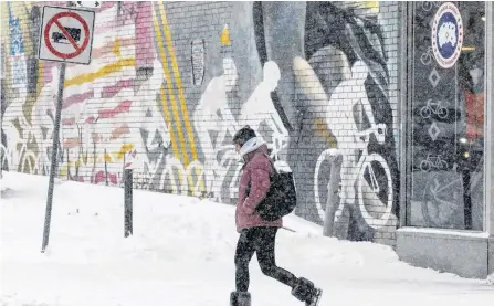  ?? CHRIS HELGREN/REUTERS ?? A woman passes a sporting goods store during a snow storm in Toronto, Ont., Jan. 18.