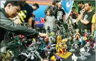  ?? GUSLAN GUMILANG/JAWA POS ?? MENARIK: Deretan koleksi mainan dipamerkan komunitas Toys Gresik menarik perhatian pengunjung Minggu Sehat.