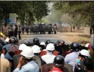  ?? (AP) ?? Protesters stand behind a makeshift barricade Monday in Naypyitaw, Burma, as police prepare to fire tear gas.